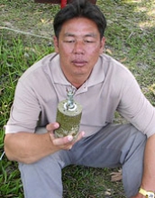 Lim holding a landmine sitting outside the village.