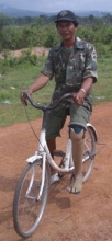 An amputee is able to ride a bicycle with an wooden limb.